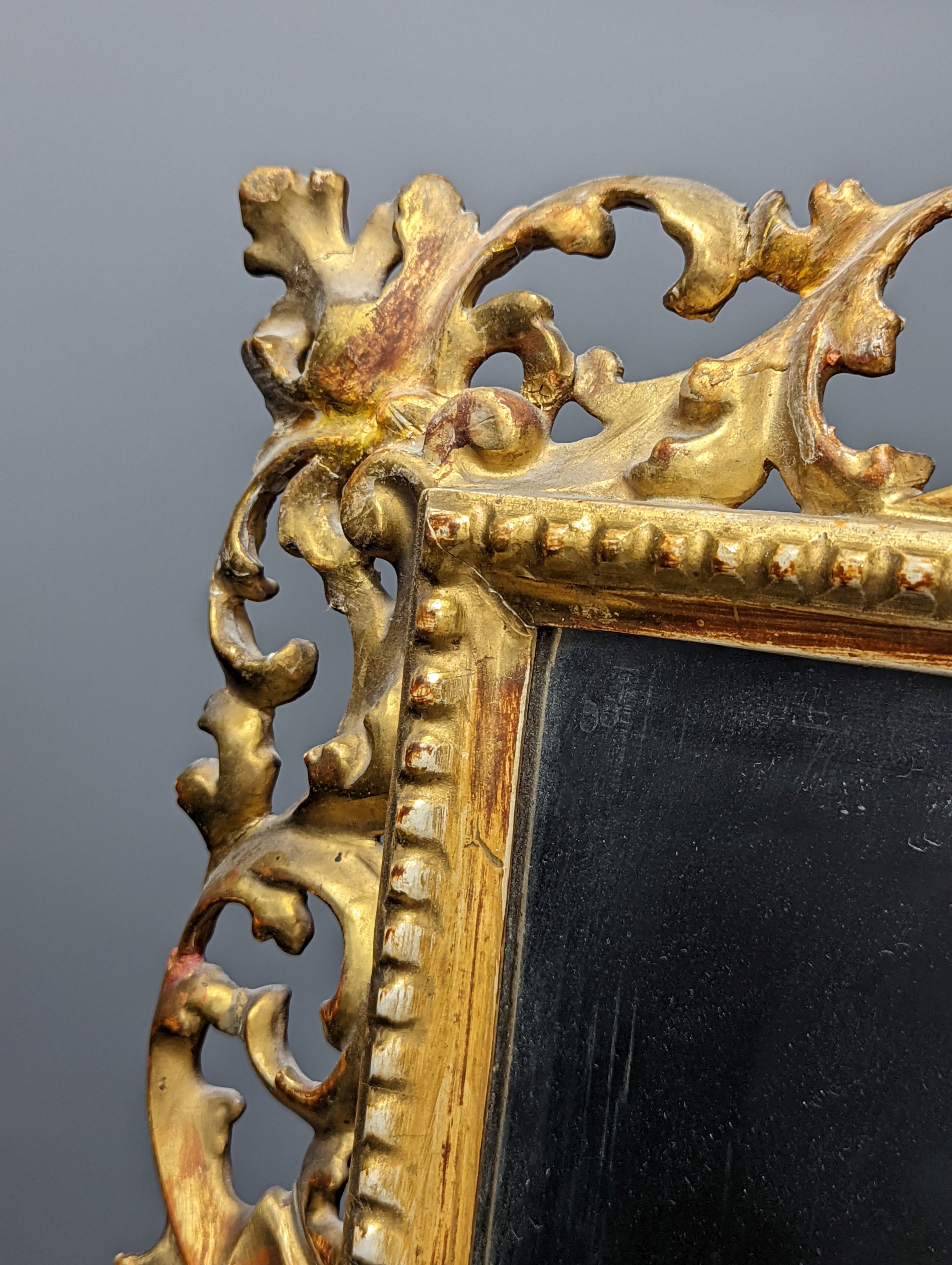 A Florentine giltwood framed mirror, with later easel back, 54 cms high x 43 cms wide.